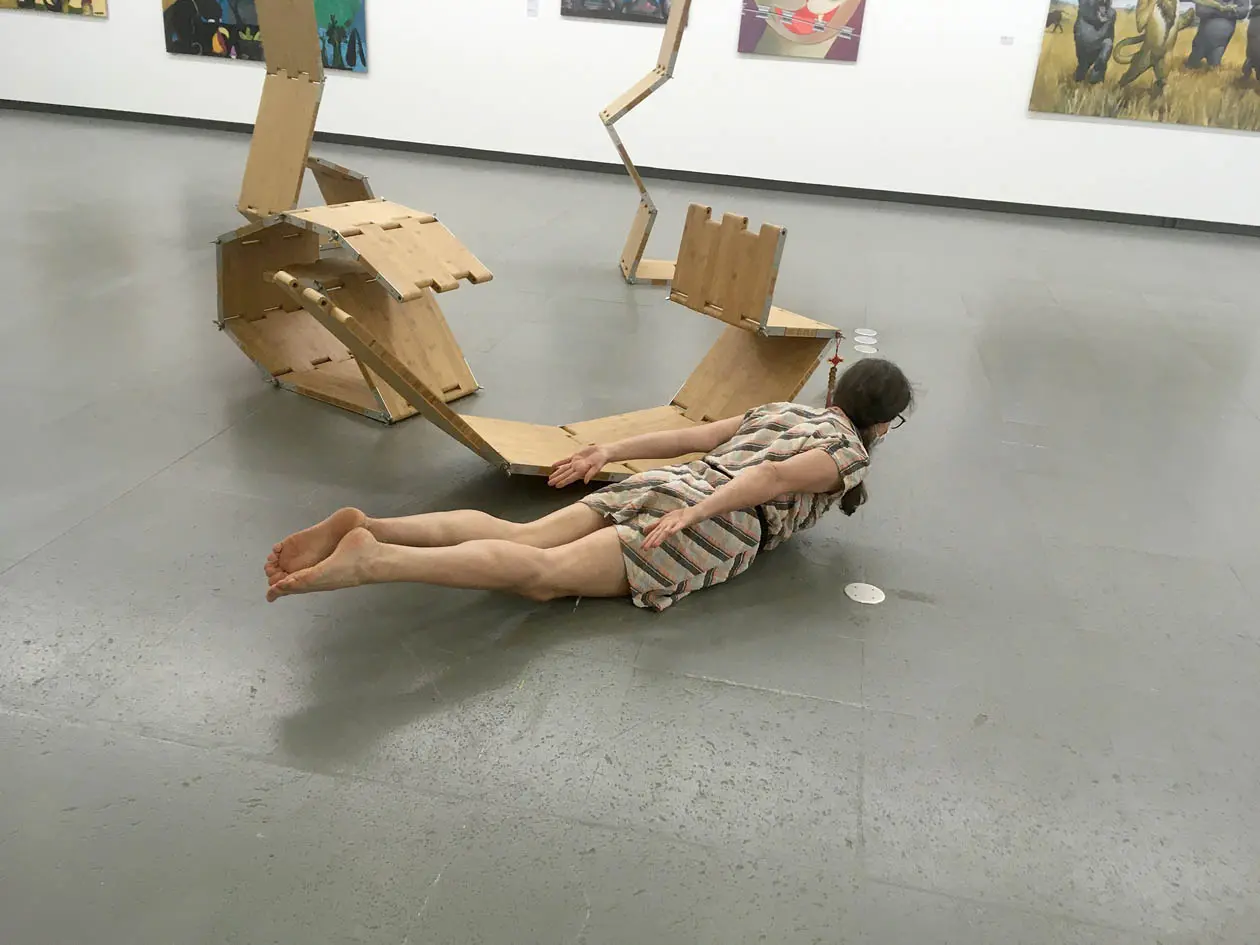a person next to a group of sculptures, doing asana pose, imitating one of the sculptures